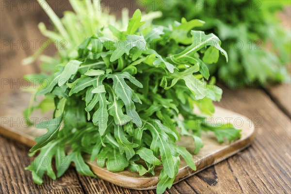 Fresh Arugula on an old wooden table as detailed close-up shot