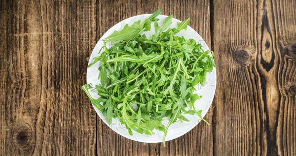 Fresh Arugula (selective focus) as detailed close-up shot on vintage background