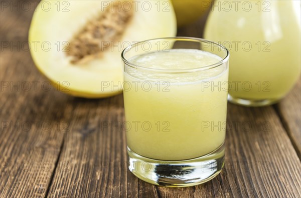 Honeydew Melon smoothie (close-up shot, selective focus) on a wooden table