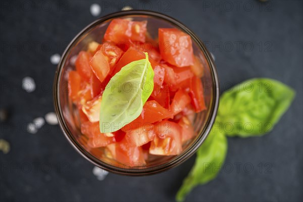 Portion of Cutted Tomatoes as detailed close up shot on a slate slab (selective focus)