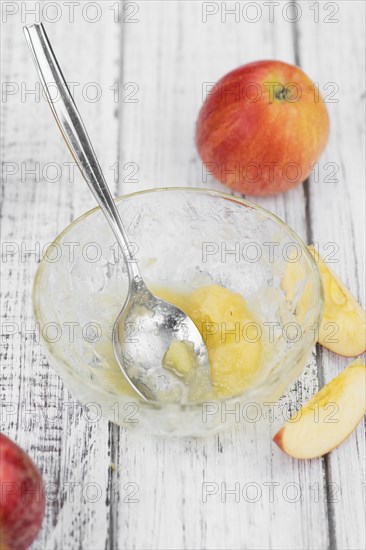 Old wooden table with fresh made Applesauce (selective focus, close-up shot)