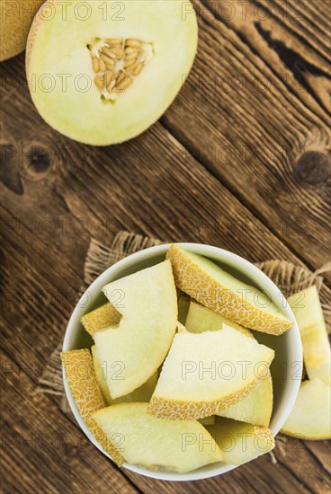 Honeydew Melon on an old wooden table as detailed close-up shot (selective focus)
