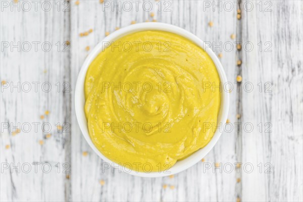 Mustard as high detailed close-up shot on a vintage wooden table (selective focus)
