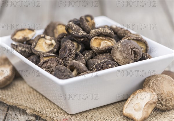 Fresh made Shiitake mushrooms (dried) on an old and rustic wooden table, selective focus, close-up