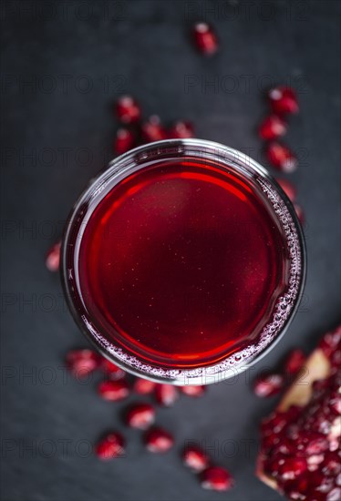 Pomegranate juice on a vintage background as detailed close-up shot (selective focus)