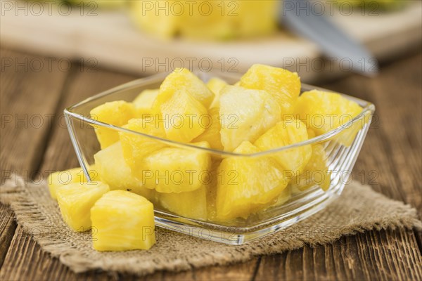 Sliced Pineapple on rustic wooden background as close-up shot