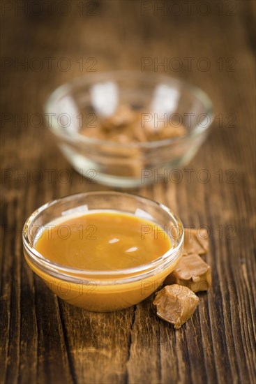 Caramel Sauce on a vintage background as detailed close-up shot (selective focus)