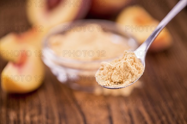 Ground Peaches as high detailed close-up shot on a vintage wooden table, selective focus