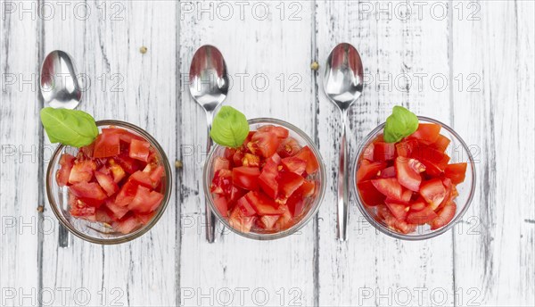 Homemade Diced Tomatoes on an wooden table (selective focus) as detailed close-up shot