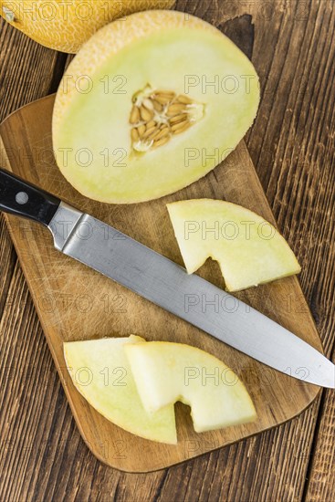 Honeydew Melon on an old wooden table as detailed close-up shot (selective focus)