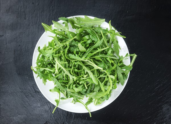 Slate slab with Arugula (detailed close-up shot, selective focus)