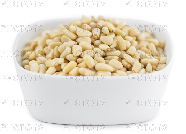Portion of Pine Nuts (as close-up shot) isolated on white background