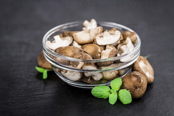 Portion of Shiitake mushrooms as detailed close up shot on a slate slab, selective focus