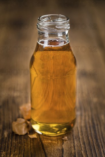 Syrup (Caramel taste) on an old wooden table as detailed close-up shot (selective focus)