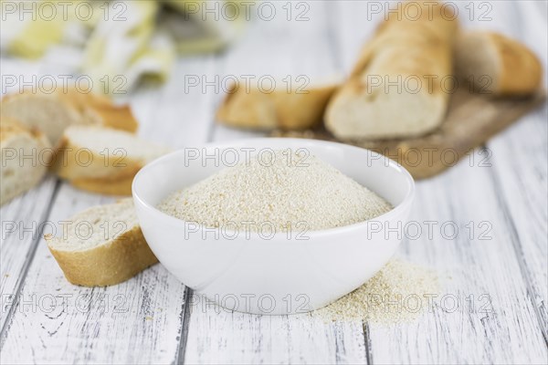 Some Bread Crumbs on a vintage wooden table (selective focus, close-up shot)