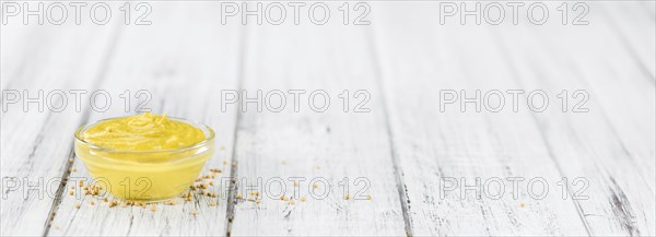 Mustard as high detailed close-up shot on a vintage wooden table (selective focus)
