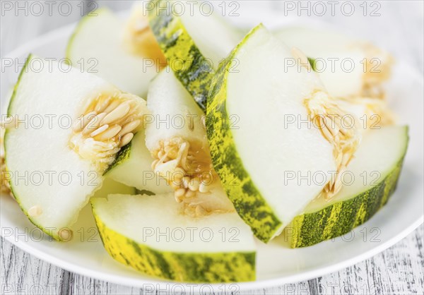 Fresh Futuro Melon as high detailed close-up shot on a vintage wooden table (selective focus)