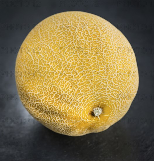Portion of Honeydew Melon on a rustic slate slab (selective focus, close-up shot)