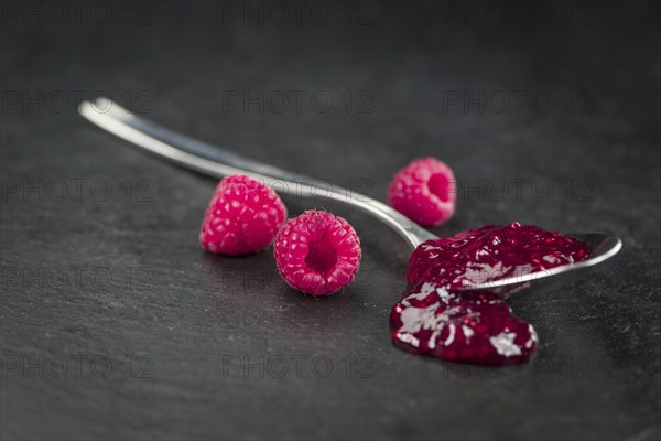Portion of Raspberry Jam on a rustic slate slab, selective focus, close-up shot