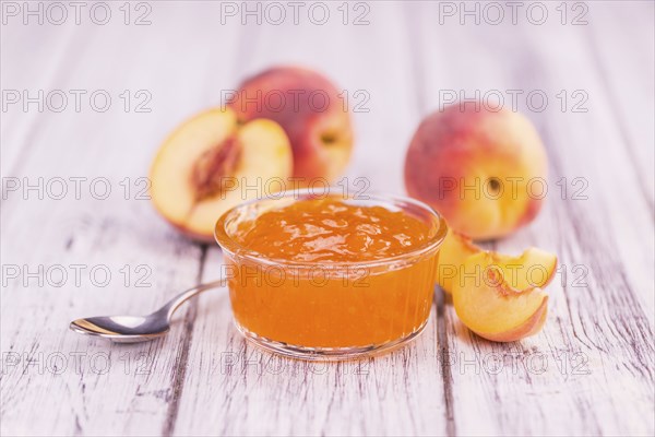 Peach Jam on an old wooden table as detailed close-up shot, selective focus