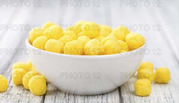 Cheese Balls on rustic wooden background (close-up shot)