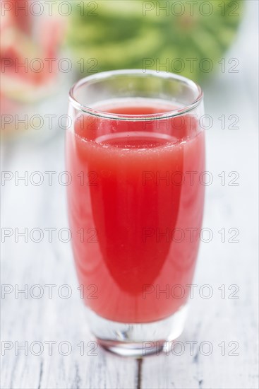 Homemade Watermelon Smoothie on an wooden table (selective focus) as detailed close-up shot