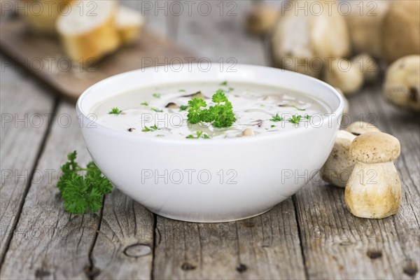 Porcini Soup on an old wooden table as detailed close-up shot, selective focus