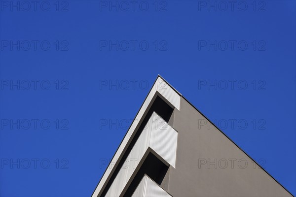 Beautiful Modern Concrete Design Building with Metal Balcony Against Blue Clear Sky in Switzerland