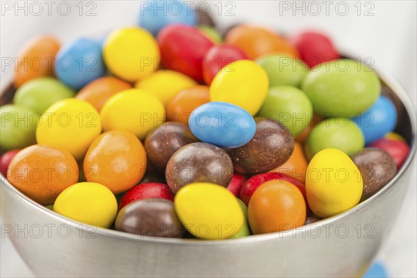 Cocolate coated Peanuts on an old wooden table as detailed close-up shot (selective focus)