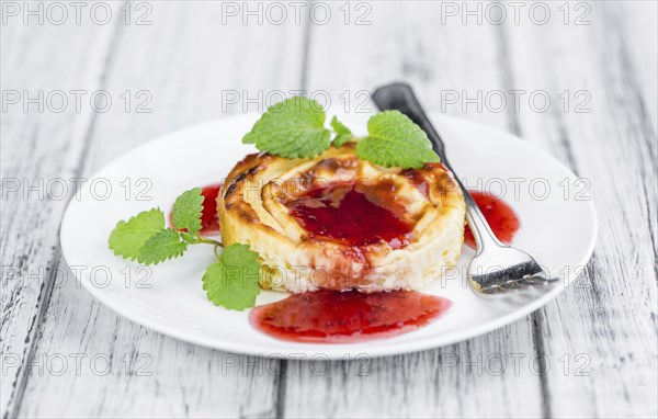Cheesecake with Sauce on an old wooden table as detailed close-up shot (selective focus)