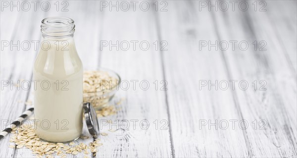 Healthy Oat Milk on a wooden table as detailed close-up shot (selective focus)