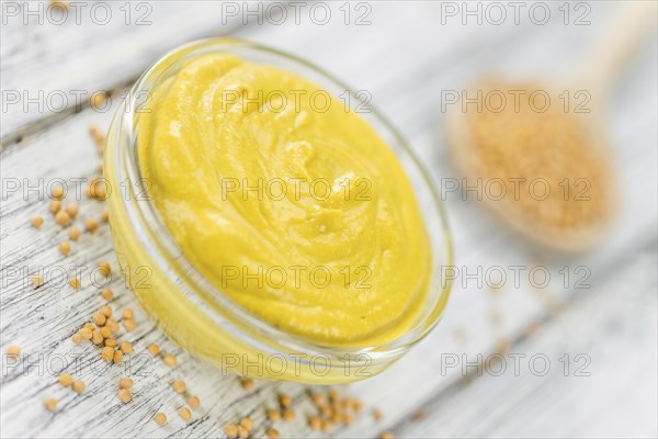 Portion of homemade Mustard on wooden background (selective focus, close-up shot)