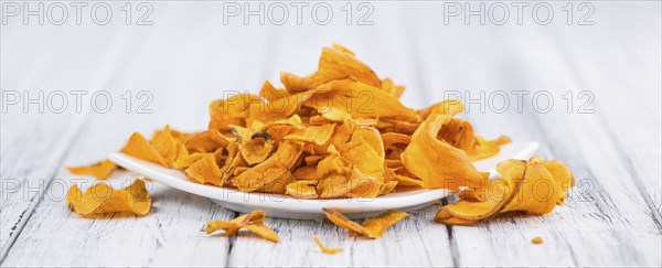 Sweet Potato Chips as high detailed close-up shot on a vintage wooden table, selective focus
