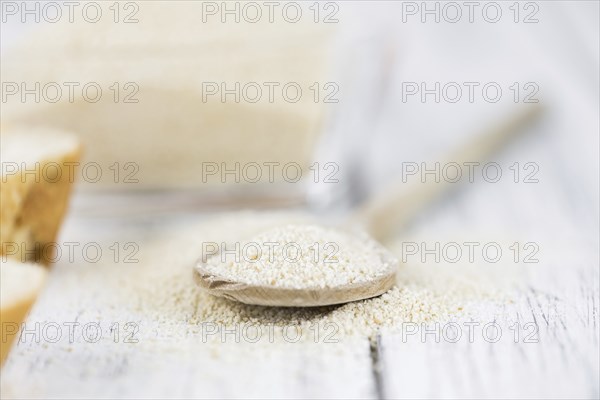 Wooden spoon with Breadcrumbs (close-up shot, selective focus) on an old wooden table