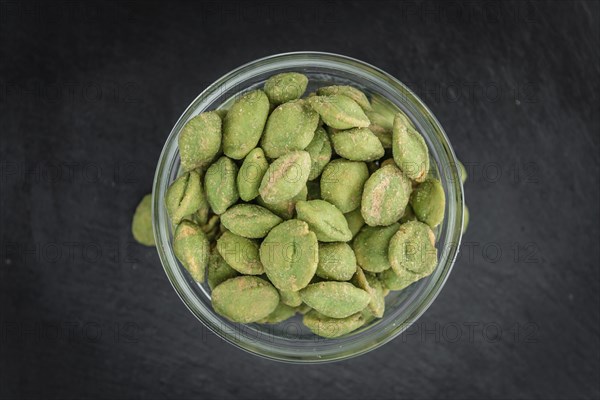 Some fresh Wasabi Peanuts on a vintage slate slab (selective focus, close-up shot)