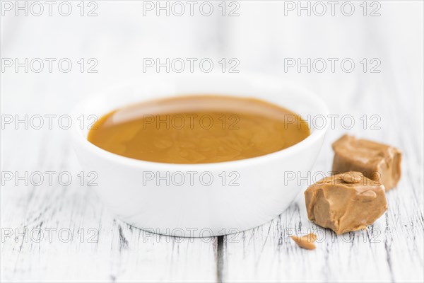 Caramel Sauce on a vintage background as detailed close-up shot (selective focus)