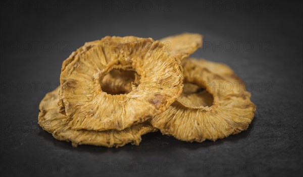 Pineapple rings (dried) on a vintage slate slab as detailed close-up shot, selective focus