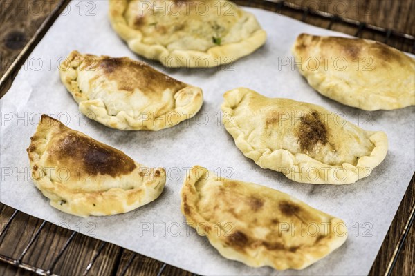 Portion of healthy Empanadas on an old wooden table (selective focus, close-up shot)