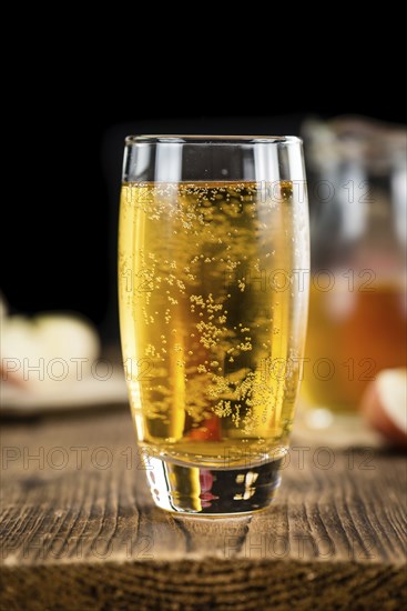 Apple Cider on an old wooden table as detailed close-up shot (selective focus)