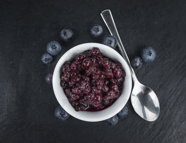 Some fresh Preserved Blueberries on a vintage slate slab, selective focus, close-up shot
