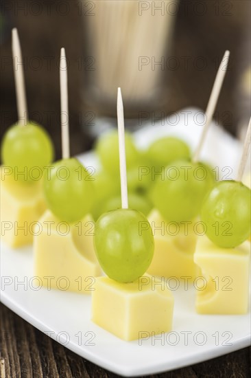 Cheese blocks with grapes as close-up shot (selective focus, partyfood)