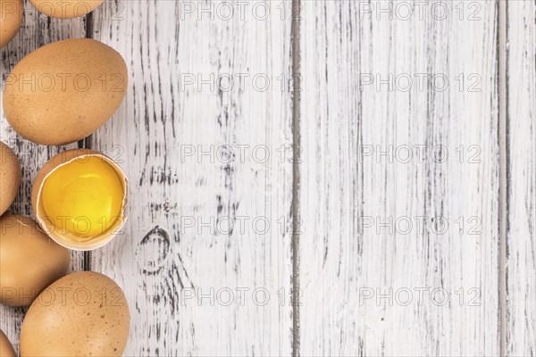 Old wooden table with fresh Raw Eggs (close-up shot, selective focus)