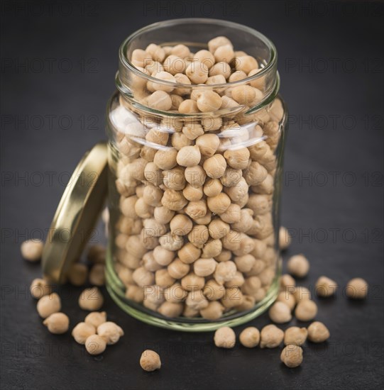 Some dried Chickpeas on a slate slab as detailed close-up shot, selective focus