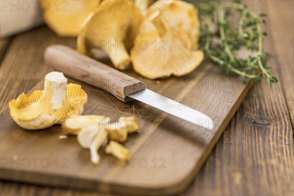 Portion of fresh harvested Chanterelles on wooden background as detailed close-up shot (selective