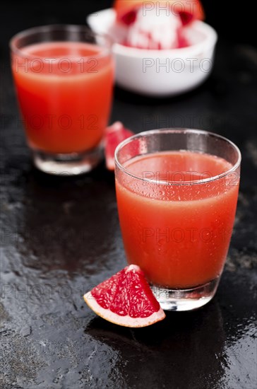 Some freshly squeezed Grapefruit Juice on a vintage background (close-up shot, selective focus)
