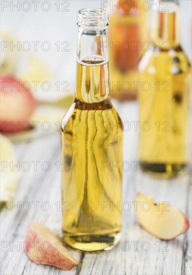 Apple Cider on an old wooden table as detailed close-up shot (selective focus)