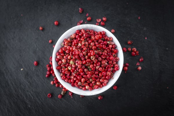 Pink Peppercorns on a vintage background as detailed close-up shot, selective focus