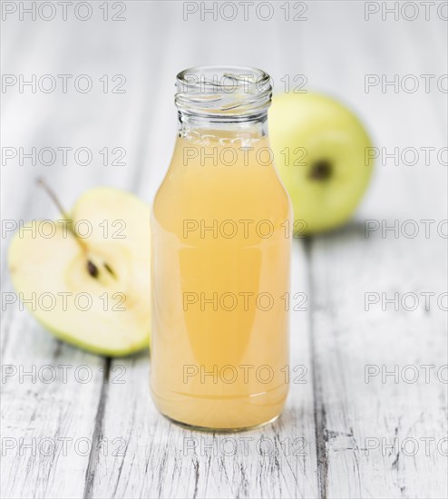 Apple Juice on an old wooden table as detailed close-up shot (selective focus)