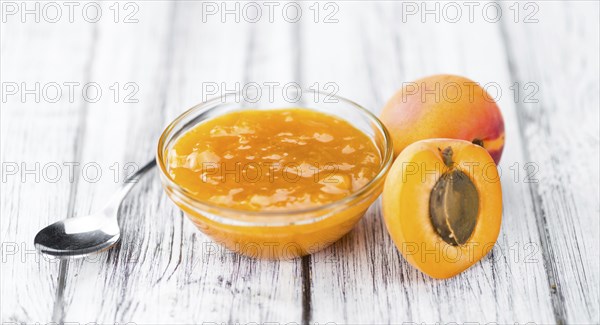 Apricot Jam on an old wooden table as detailed close-up shot (selective focus)