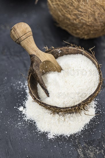 Some fresh made Coconut flour on a vintage slate slab (selective focus)